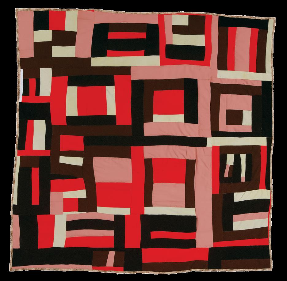 A photo of a quilt with a geometric pattern. Strips of pink, red, white, black, and brown are arranged either horizontally or vertically, resulting in a grid-like effect.